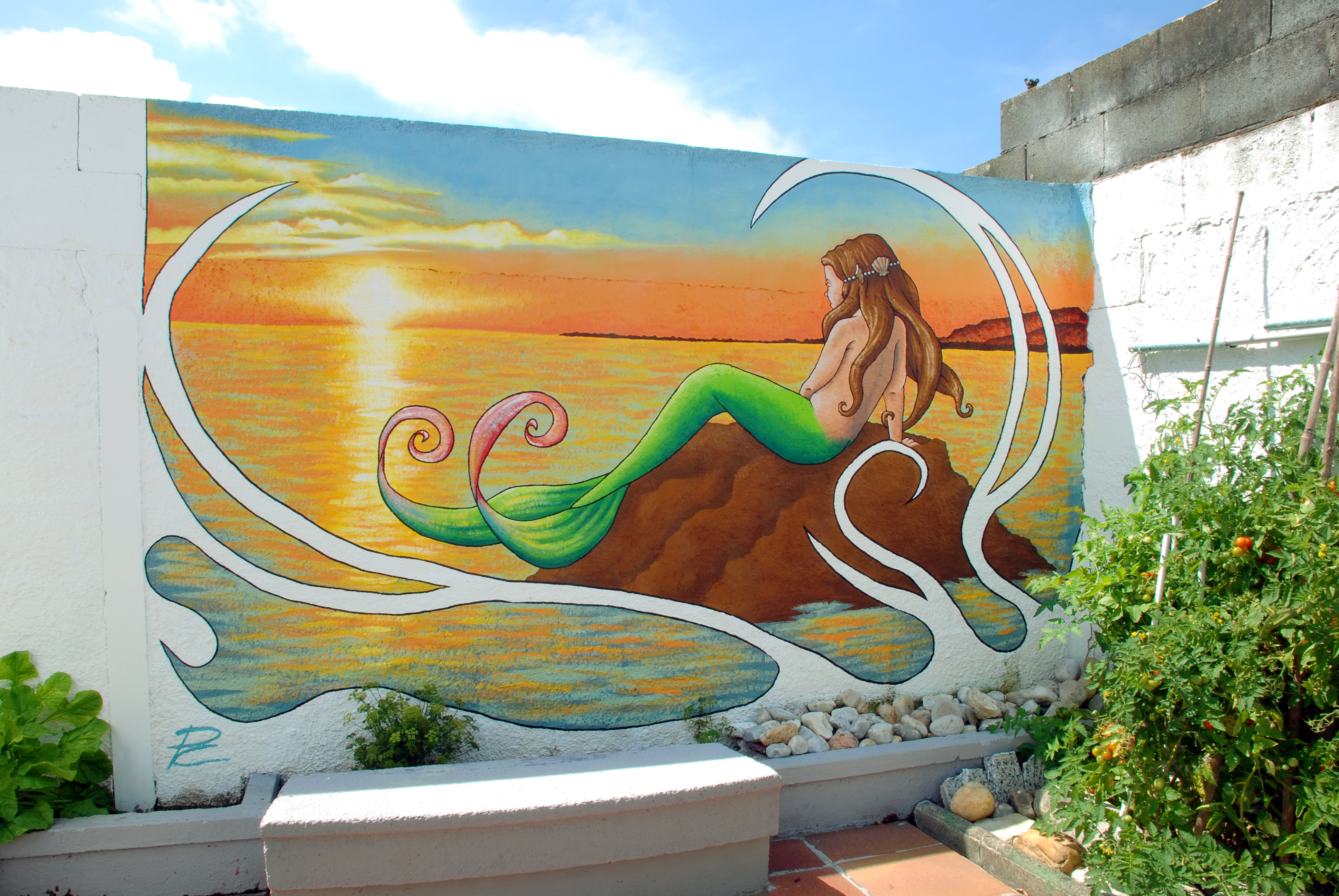 mural de sirena con puesta de sol de fondo